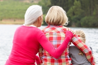 3 generations of women sitting on a dock